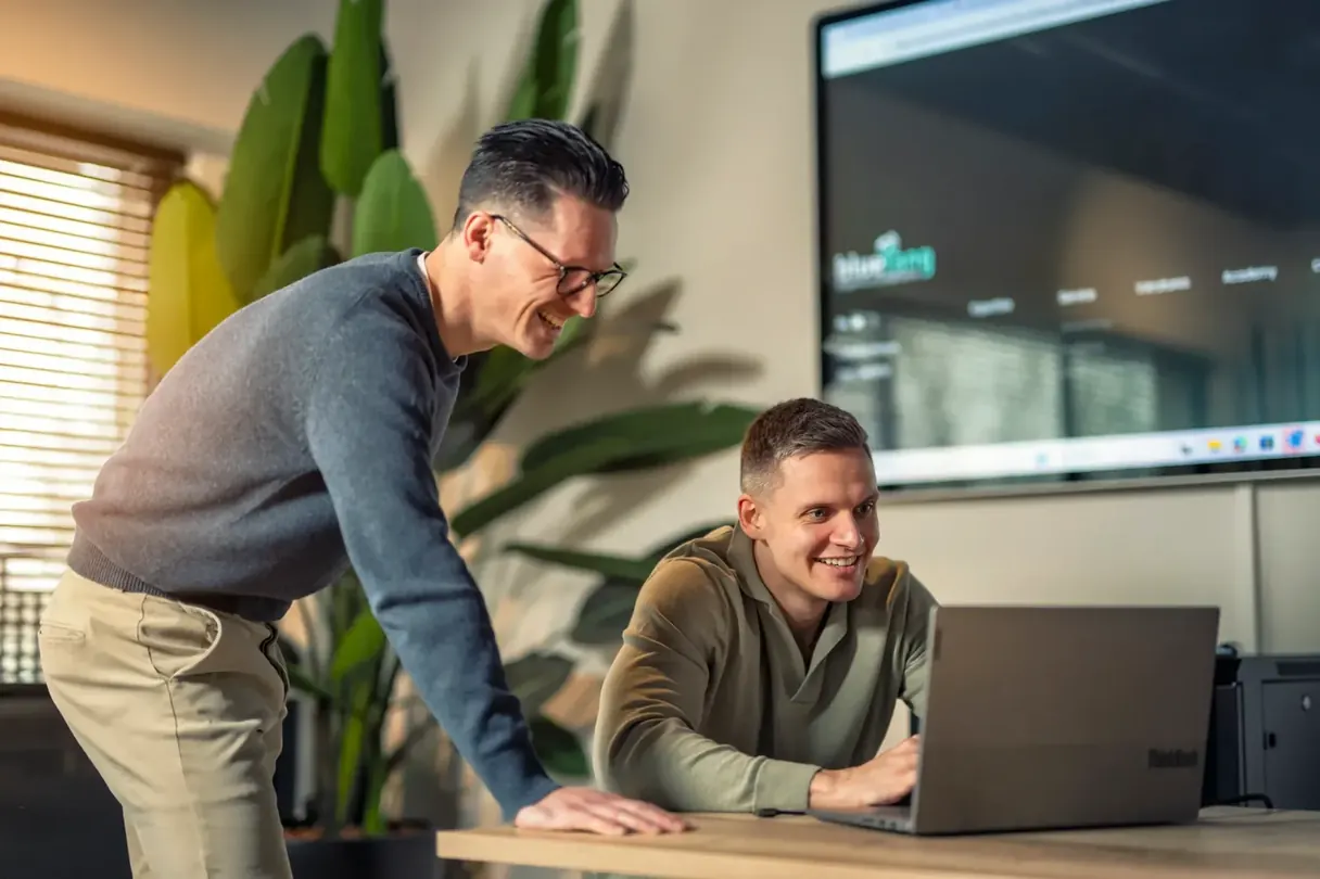 Een Bluetang collega begeleidt een junior achter de laptop